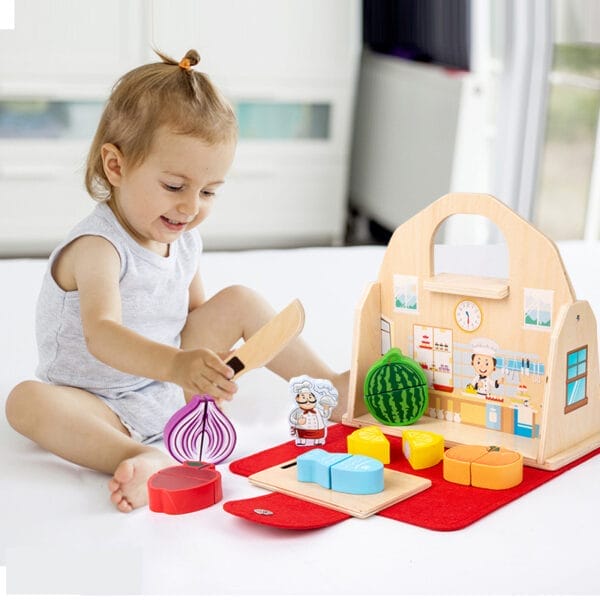 Un enfant joue avec une cuisine en bois et découpe des légumes et des fruits. Une mini-cuisine portable pour les enfants créatifs.