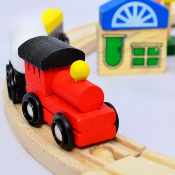 Rote Holzeisenbahn auf Holzschienen mit buntem Blockhaus