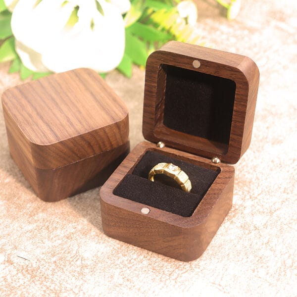 Elegante Ringschatulle aus Walnussholz mit goldenem Verlobungsring. Perfekt für Heiratsanträge.