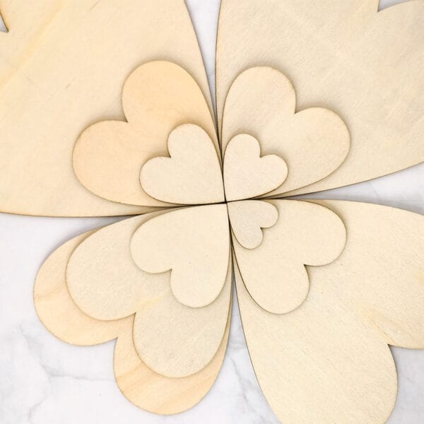 Ineinander verschachtelte, lasergeschnittene Holzherzen; unbearbeitete Holzscheiben zum Basteln.