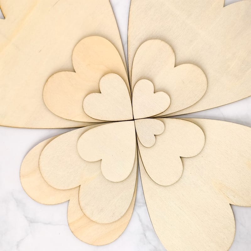 Ineinander verschachtelte, lasergeschnittene Holzherzen; unbearbeitete Holzscheiben zum Basteln.