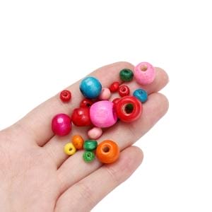 Hand mit bunten Holzperlen, ideal für DIY-Projekte und Schmuck
