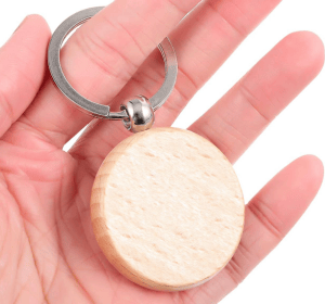 Holz Schlüsselanhänger: Leerer Buchenholzanhänger in Hand gehalten.