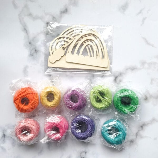 Unfertiges Regenbogen-Bastelset aus Holz mit bunter Juteschnur. DIY-Regenbogendekoration.