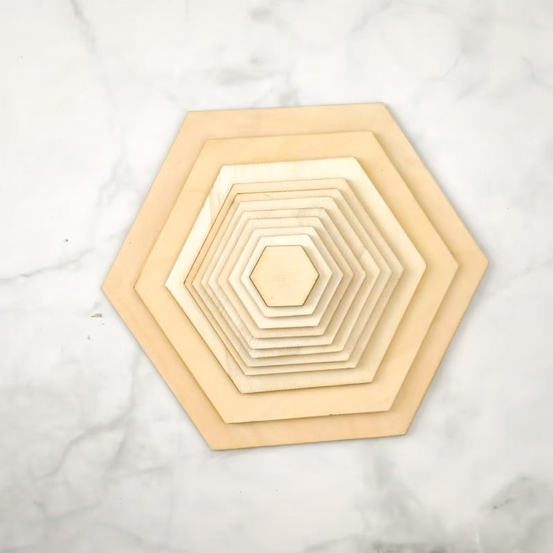 Ineinander verschachtelte, unbehandelte, lasergeschnittene Holzsechsecke. Großhandel mit unbehandelten Holzscheiben für Heimwerkerarbeiten.