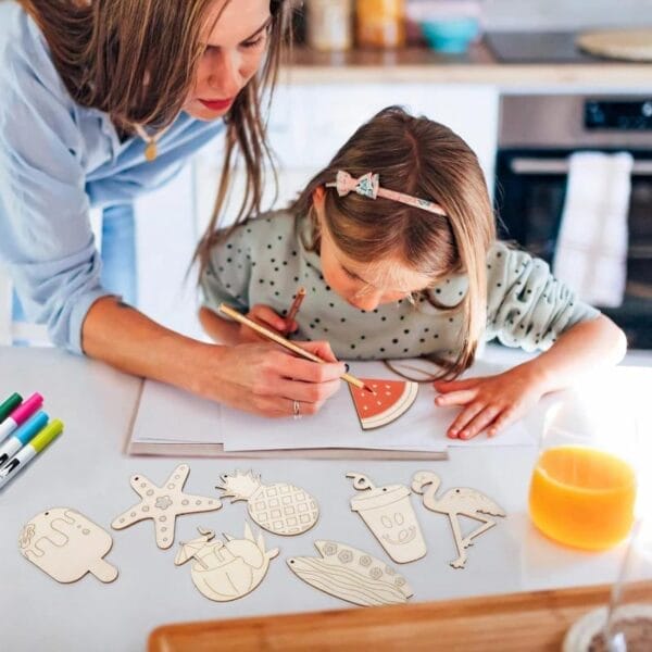 Mutter und Tochter bemalen unfertige Sommerornamente aus Holz. Bastelarbeiten zum Thema Strand.