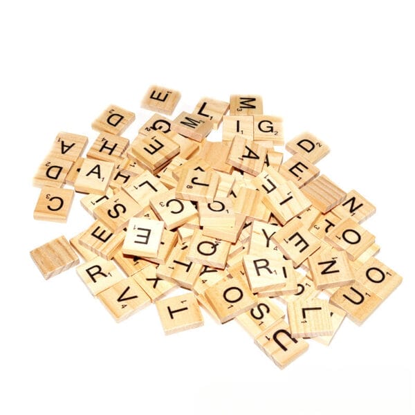 Verstreute Scrabble-Steine aus Holz mit verschiedenen Buchstaben. Ideal zum Basteln und für den Großhandel.