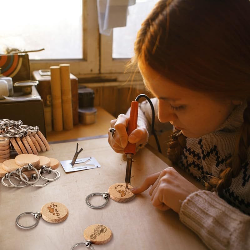 Mädchen fertigt individuelle Schlüsselanhänger aus Holz mit Lasergravur. Leere Schlüsselanhänger aus Buchenholz, bereit für personalisierte Designs.