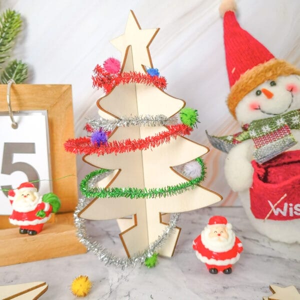 Mini-Weihnachtsbaum-Bastelset aus Holz mit buntem Lametta und Weihnachtsmannfiguren. Perfekt für Weihnachtsbasteleien mit Kindern!