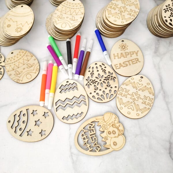 Hölzerne Ostereierformen und -marker, bereit zum Basteln für Kinder. Mit der Nachricht „Frohe Ostern“.