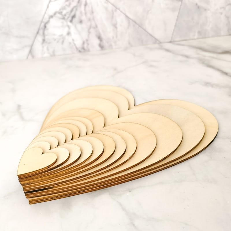 Stapel unbearbeiteter, lasergeschnittener Holzherzen, perfekt zum Basteln.