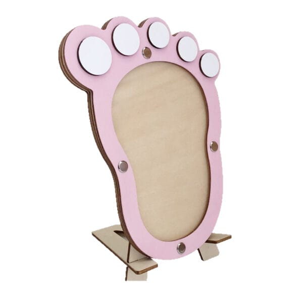 Rosa Bilderrahmen aus Holz mit Baby-Fußabdrücken und leeren Feldern für Fotos. Ideal als Taufgeschenk.