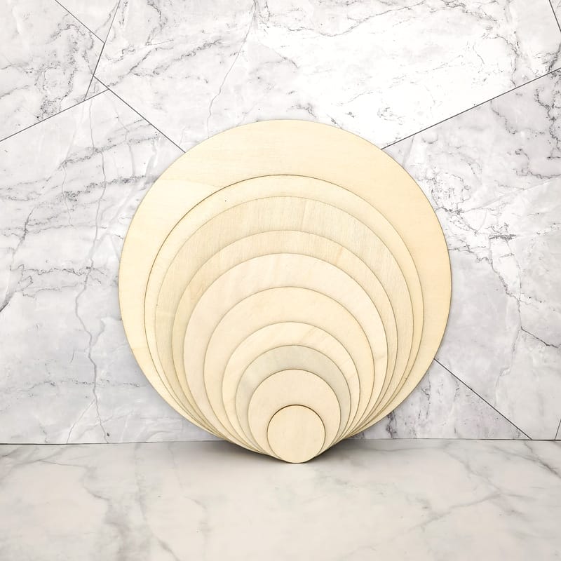Ineinander verschachtelte, unbehandelte Holzkreise, ideal für Bastelarbeiten und Laserschneiden. Holzscheiben im Großhandel erhältlich.