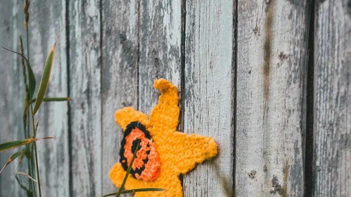 Gehäkelte Sonnenblume auf verwittertem Holzzaun. DIY-Blumenhandwerk aus Holz.