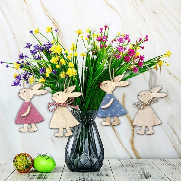 Bezaubernde Osterhasen-Ornamente aus Holz hängen in einer Vase mit Frühlingsblumen. Dekorative Holzhasen im Großhandel, perfekt für Ostern.