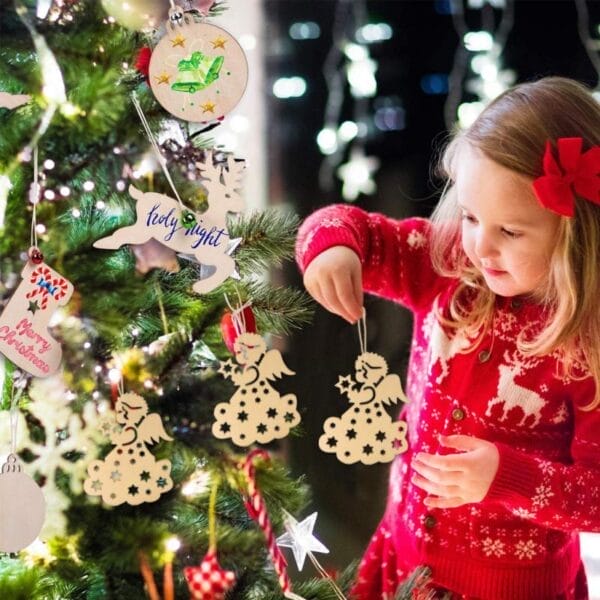 Entzückendes Mädchen schmückt den Weihnachtsbaum mit lasergeschnittenen Holzornamenten. „Heilige Nacht“, „Frohe Weihnachten“-Text sichtbar.