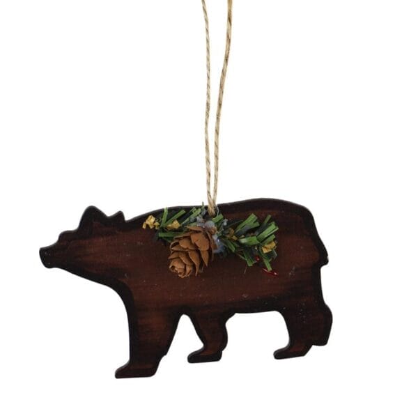 Rustikaler Weihnachtsschmuck aus Holz in Form eines Bären mit Tannenzapfendetail.