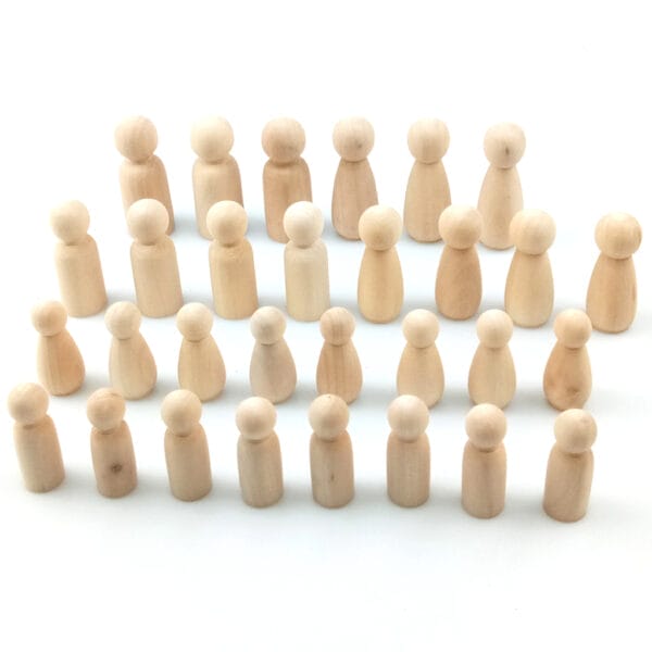 Viele kleine, unbemalte Holzpuppen in Reihen angeordnet. Ideal für DIY-Malprojekte.