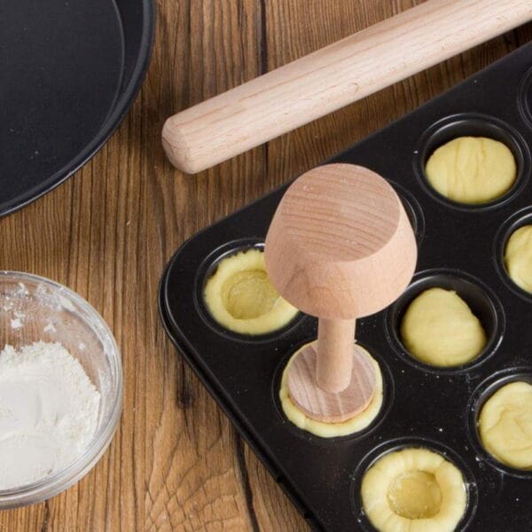 Mit diesem hölzernen Gebäckstempel können Sie perfekte Törtchenböden in einer Muffinform herstellen.