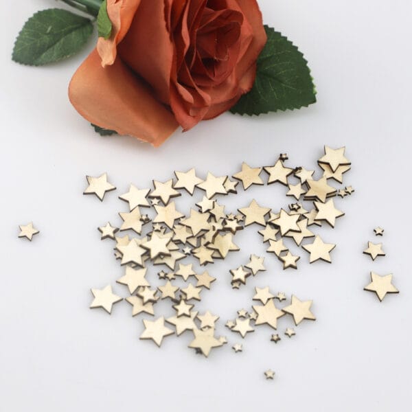 Holzsterne, verstreut neben einer orangefarbenen Rose. Ideal für Bastelarbeiten, Scrapbooking und Partys!