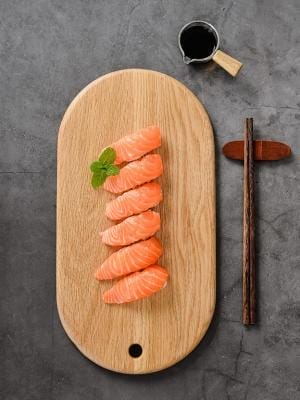 Ovales Schneidebrett aus Eichenholz mit Sushi und Sojasauce. Elegantes Brotbrett aus Holz.