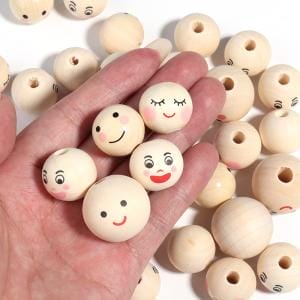 Holzperlen mit Gesicht in einer Hand, DIY Bastelset für Kinder