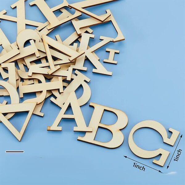 Holzbuchstaben des Alphabets, 1 Zoll groß, verstreut auf blauem Hintergrund.