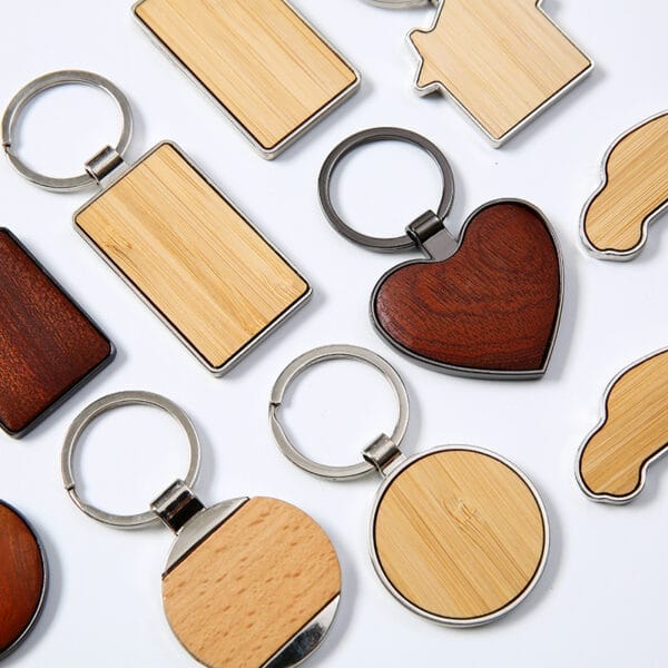 Verschiedene Schlüsselanhänger aus Holz mit Metallringen. Herz-, Auto- und rechteckige Designs.