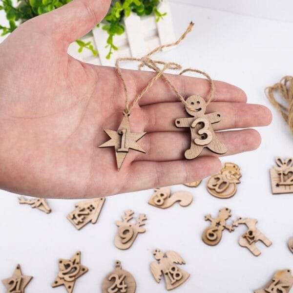 Hand hält hölzerne Adventskalenderzahlen, darunter Stern- und Lebkuchenmannformen. Großhandel mit Holzornamenten.