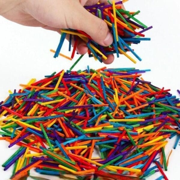 Eine Handvoll bunter Holzstäbchen zum Basteln, ideal für Kinder. Im Großhandel erhältlich.