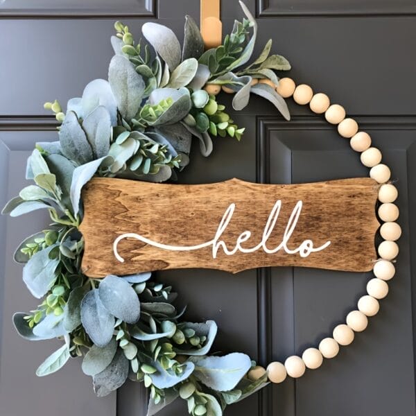 Holzperlenkranz mit Eukalyptus und einem "Hallo"-Schild. Elegante Tür- oder Wanddekoration.