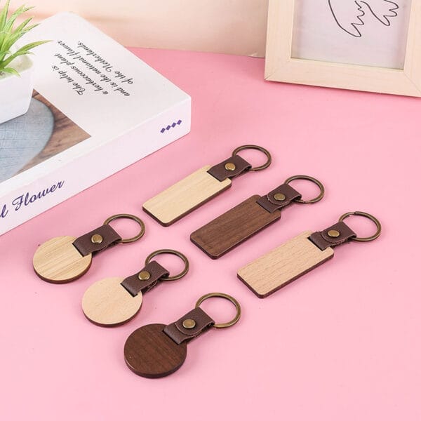 Fünf personalisierbare Schlüsselanhänger aus Holz mit braunen PU-Lederbändern. Perfekte personalisierte Geschenke!