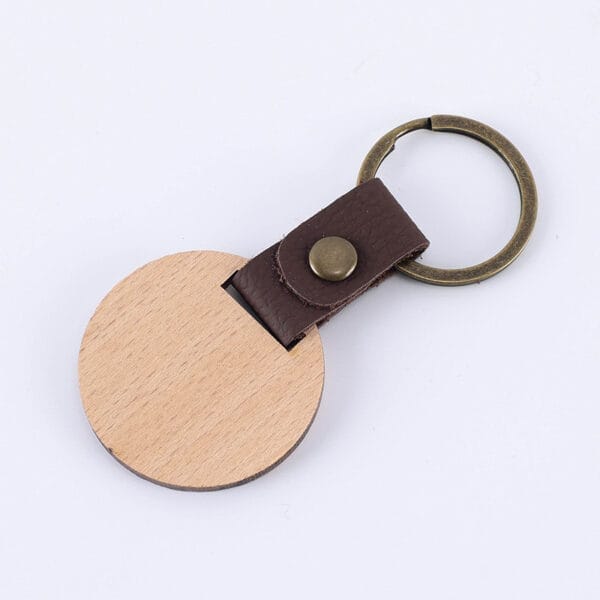 Runder Schlüsselanhänger aus Holz mit braunem PU-Lederband. Individualisierbar.