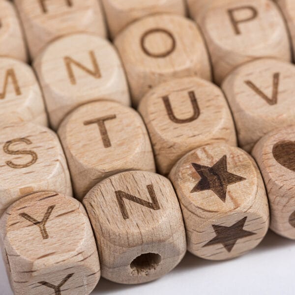 Buchstabenperlen aus Holz für DIY-Projekte von Kindern. Alphabetperlen aus Buchenholz.