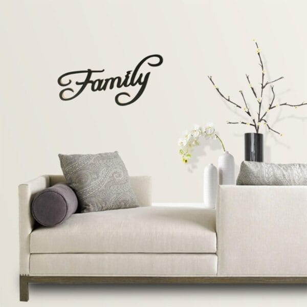 Schwarzes „Familien“-Wandbild aus Holz über einem modernen beigen Sofa.
