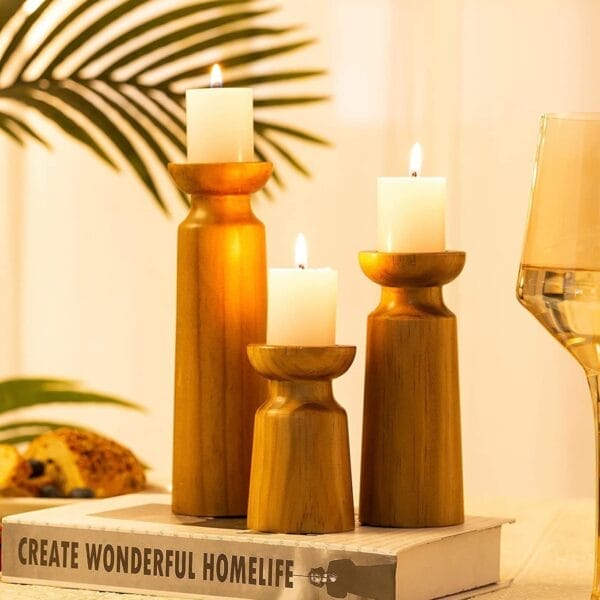 Drei Kerzenhalter aus Holz mit Stumpenkerzen, rustikale Tischdekoration. Kerzenhalter aus Holz im Großhandel.