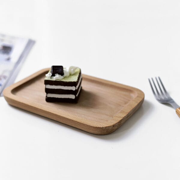 Kleines Holztablett mit einem Matcha-Kuchen. Serviertablett aus japanischem Buchenholz.