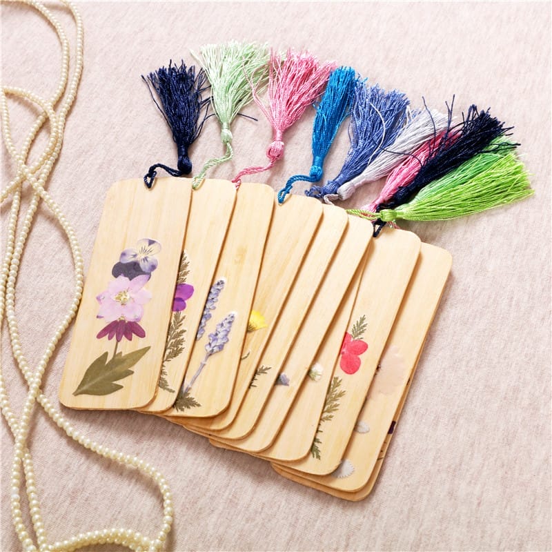 Holzlesezeichen mit Trockenblumen und bunten Quasten