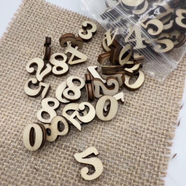 Auf Sackleinen verstreute Holzzahlen, ideal für Heimwerkerprojekte. Lernmaterialien im Montessori-Stil.