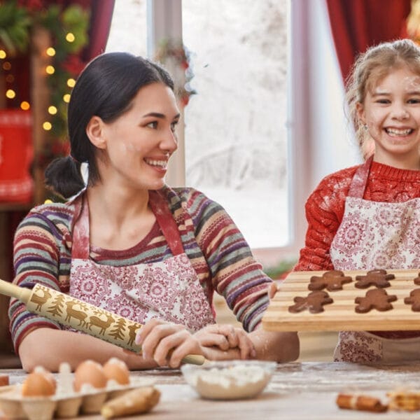 Zwei Frauen backen Weihnachtsplätzchen mit einem hölzernen Rentier-Nudelholz. Weihnachts-Nudelholz im Großhandel.