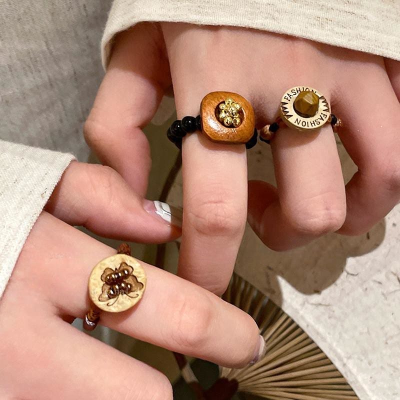 Frauenhände modellieren einzigartige Vintage-Ringe aus braunen Holzperlen. Ringe aus Holz.