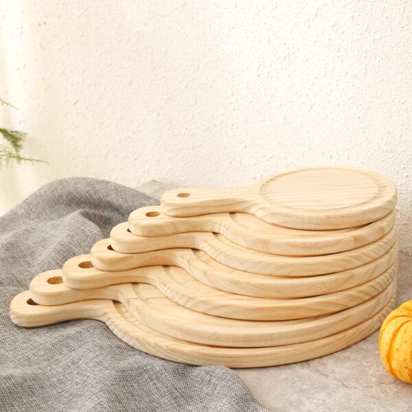 Stapel runder Pizzabretter aus Holz mit Griffen. Serviertabletts aus Kiefernholz im Großhandel in den Größen 6, 7 und 9 Zoll.