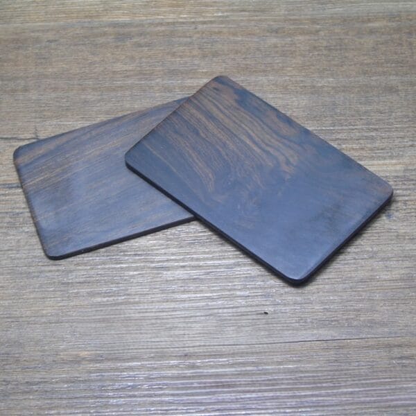 Zwei schwarze Visitenkarten aus Ebenholz, ideal zum Gravieren oder Beschriften. Visitenkarten aus Holz im Großhandel erhältlich.