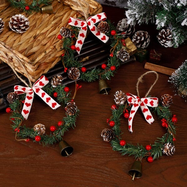 Drei Mini-Weihnachtskränze mit Glöckchen und rotem Herzband. Perfekt für die Weihnachtsdekoration oder den Großhandel.
