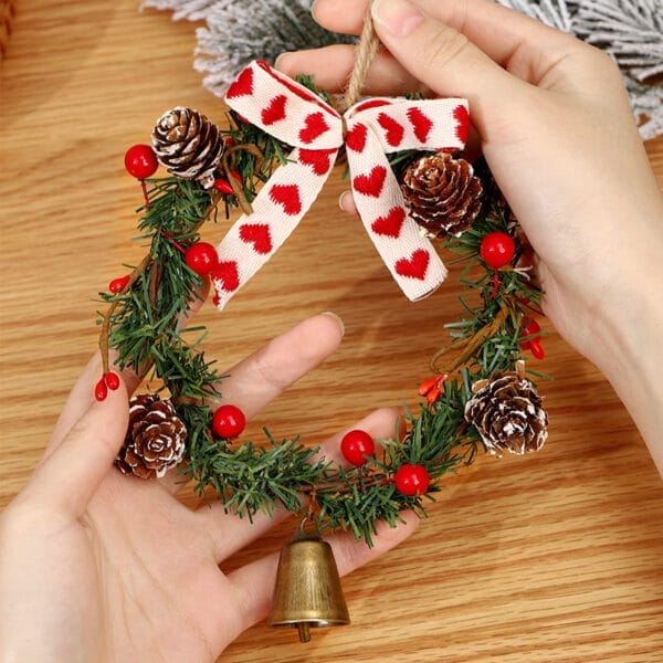 Handgefertigter Weihnachtskranz mit Tannenzapfen, Beeren und einer Herzschleife. Perfekt für die Weihnachtstürdekoration.