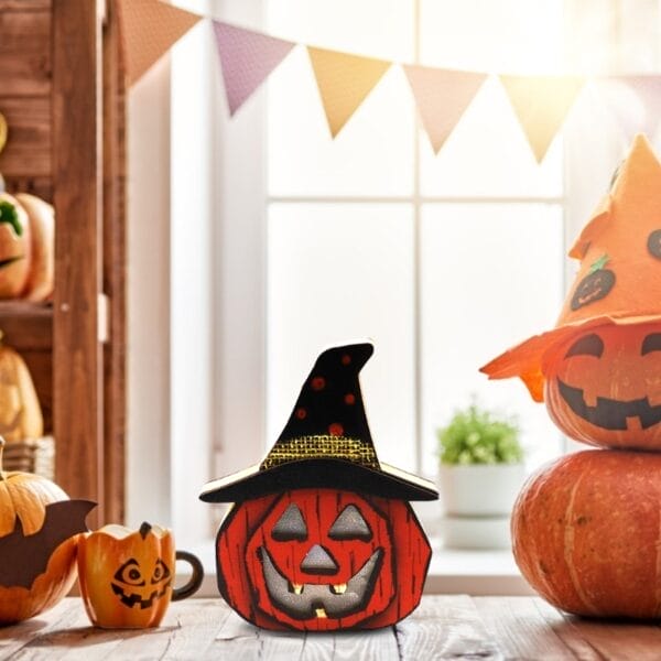 Hölzerne Halloween-Kürbislaterne mit Hexenhut, festliche Dekoration.