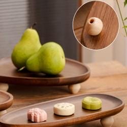 Serviertablett aus Holz mit Birnen und Süßigkeiten. Snackplatte aus Akazienholz mit Beinen.