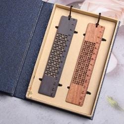 Zwei handgefertigte Lesezeichen aus Holz mit lasergravierten Mustern im chinesischen Stil und Linealmarkierungen, präsentiert in einer Geschenkbox.