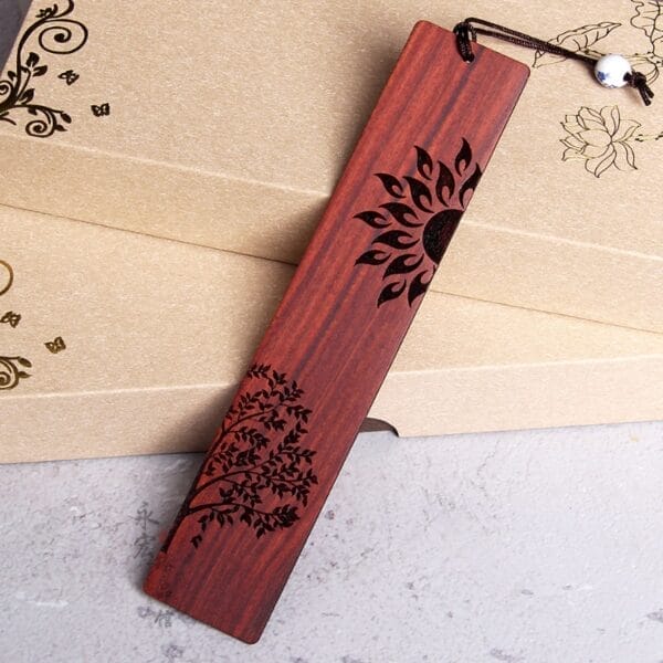Handgefertigtes, lasergraviertes Holz-Lesezeichen mit Sonnen- und Baummotiv im chinesischen Stil.