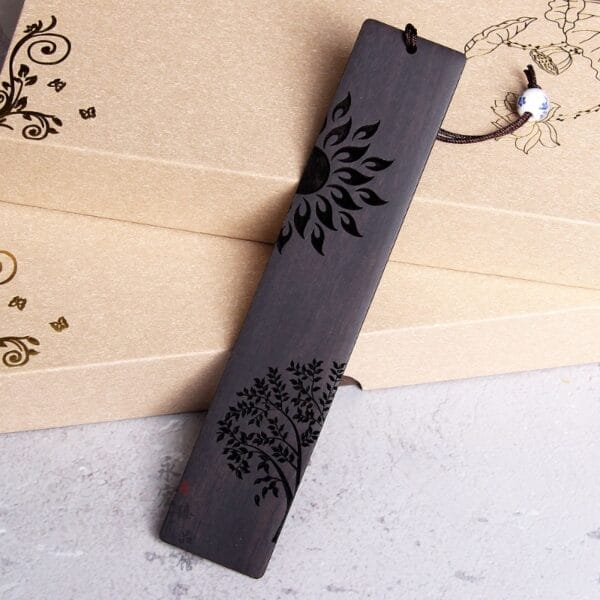 Handgefertigtes, lasergraviertes Holz-Lesezeichen mit chinesischem Sonnen- und Baummotiv.